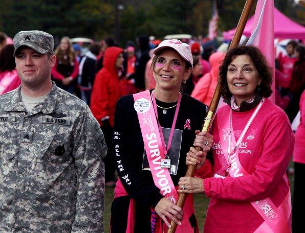 Survivor and event chairwoman Donna Wilbur (right) with fellow survivor Candice Cantellimeklis being escorted by members of the Armed Forces during the 2012 opening ceremonies.