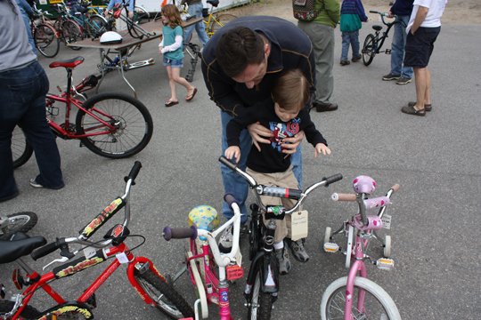 Curt Schroeder of Bow helps son Will, 3, onto a bike.