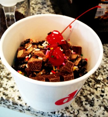 A bowlful of cappucino and cookies and cream frozen yogurt from Dips, topped with Oreos, Kit Kat, Heath bar, sprinkles and cherries.