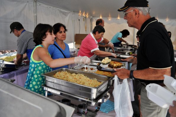 Andria Norris and Panagiota Mansur serve a heaping helping of rice to Bill Heydt.