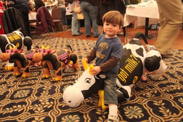Mason Christensen, 2, of New London, rides inflatable cow. He's a "big time mac and cheese fan," his mom said.