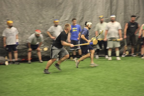 Nick Valade and Ray Valas scurry to get control of the sliotar, or ball, during a recent practice at the Concord Sports Center.