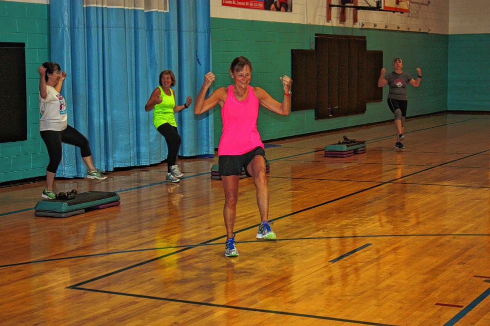 Bonnie Larochelle pumps her fists as she leads her 6 a.m. aerobics class at the YMCA. Look at how awake and energetic everyone is! (JON BODELL / Insider staff) -