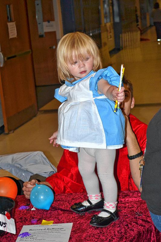 Avah Mitchell, 16 months, gets ready to hand out some pencils. (TIM GOODWIN / Insider staff) - 
