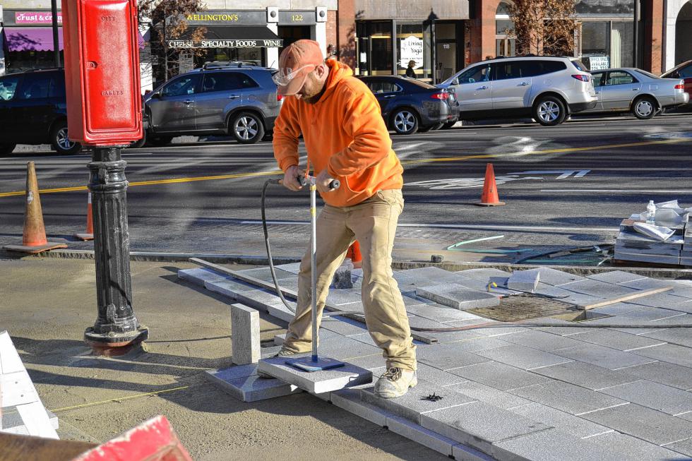 Jason Lebel from Stoneage Stoneworks out of Berwick, Maine, presses some pavers into place using some contraption that saves him from having to bend over and break his back doing it by hand. (TIM GOODWIN / Insider staff) - 
