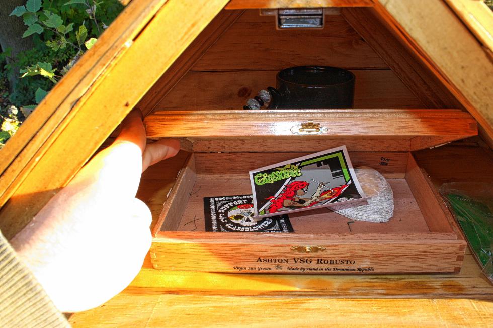 What's inside that secret compartment of the Cypress Street library? Gold? A small emu? Nope. That's a cigar box with some stickers and a seashell in it. Behind the box is a coffee mug. Homeowner Chris Moorse says all that stuff is fair game, too. (JON BODELL / Insider staff) - 
