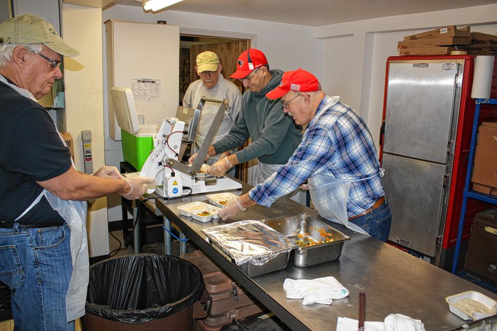 From left: Wayne Moore, Joe LaCroix, Mike Drago and Steve Indyk prepare meals to be delivered for the Meals on Wheels program at the Community Action Program Belknap-Merrimack Counties center in Concord. (JON BODELL / Insider staff) - 
