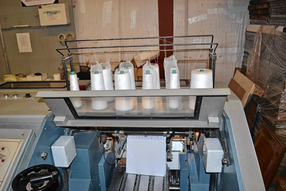 This machine sews the signatures together. (TIM GOODWIN / Insider staff) - 
