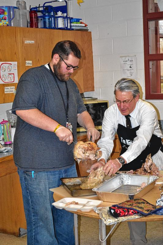 Will Hodges (left) and Peter Bombaci work to get the turkey set for slicing. (TIM GOODWIN / Insider staff) - 
