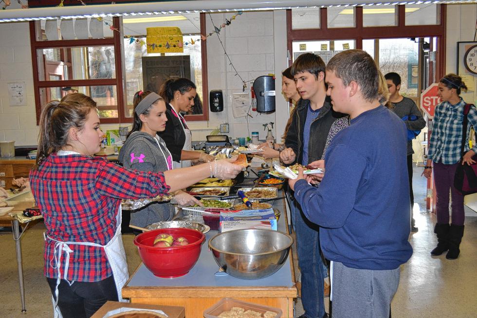 Student helpers dish out some delicious food during the annual Thanksgiving feast in the Concord High special education department. (TIM GOODWIN / Insider staff) - 
