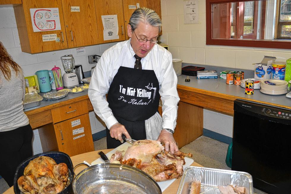 Special education teacher Peter Bombaci slices up one of the many turkeys, 47 pounds in all, for the annual Thanksgiving feast in his classroom last week. (TIM GOODWIN / Insider staff) - 
