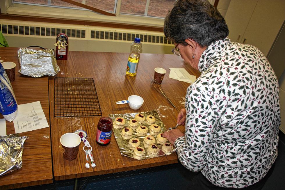Sue Edy fills her raspberry and almond shortbread thumbprint cookies before popping them in the oven. (JON BODELL / Insider staff) - 
