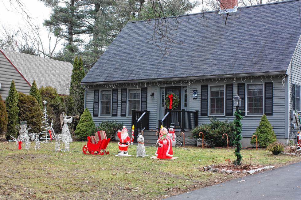 Some houses, like this one on Shawmut Street, don’t need darkness to show off. Here we see those classic plastic Santa and Mrs. Claus lawn ornaments, complete with wooden sleigh. For ambiance, there are candy cane poles lining the front of the house and wiry lit winter figurines next to the Clauses. (JON BODELL / Insider staff) - 

