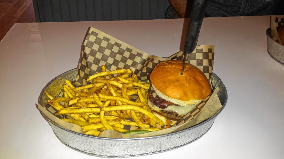 The Concord's Own burger comes with bacon, cheddar, an apple slice and maple syrup, though Tim was afraid to try the syrup. (TIM GOODWIN / Insider staff) -