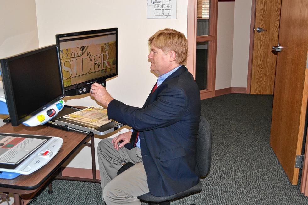 David Morgan, the new president and CEO of the N.H. Association for the Blind, uses a device that magnifies images on a screen to brush up on the Insider’s coverage of the association. (TIM GOODWIN / Insider staff) - 
