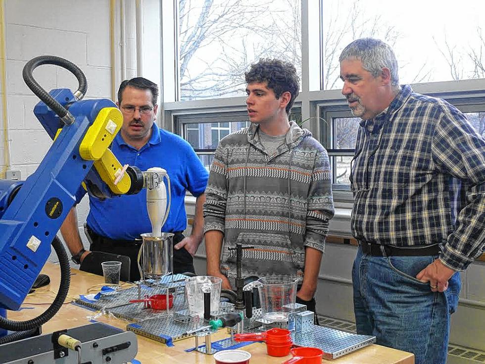 Students Glen Collins (left) and Kris Hewes, and Professor Joe Cunningham watch as a robot stirs up the batter. (Courtesy photo) - 
