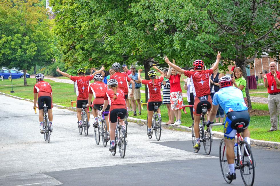 We’d be raising our arms too if we just biked across almost the entire country and got a standing ovation from our teachers like these St. Paul’s School riders. (TIM GOODWIN / Insider staff) - 
