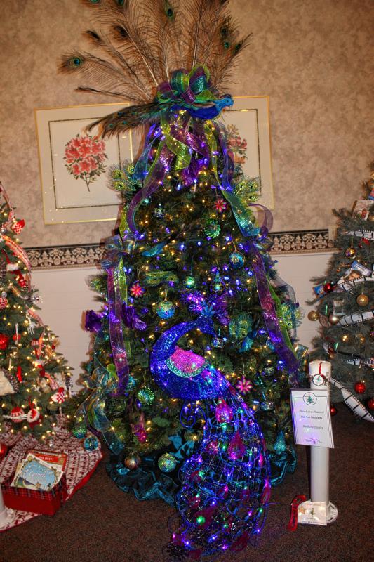 The Proud as a Peacock tree, donated by Barbara Dooley, won second place for Most Beautiful Tree. The purple lights sure are eye-catching from across the room. (JON BODELL / Insider staff) - 
