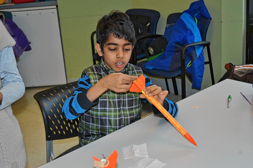 Vaibhav Rastogi, 8, carefully attaches the ignition switch to his rocket. (TIM GOODWIN / Insider staff) - 
