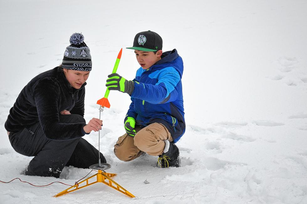 Discovery Center intern Nicole Lyle and Jacob Wirtz, 10, make sure his rocket is perfectly aligned before sending it hundreds of feet into the air. (TIM GOODWIN / Insider staff) - 
