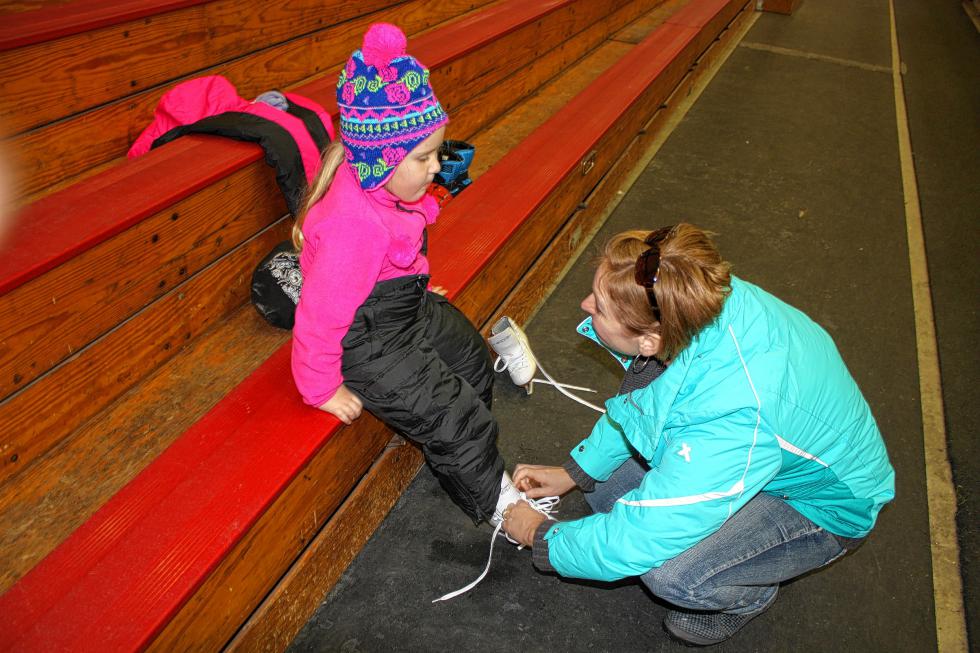 Alaina, 4½, gets some help lacing up her skates before taking an ice skating lesson at Everett Arena in Concord last week. This was Alaina's third lesson, making it the third time she'd ever put on skates. (JON BODELL / Insider staff) -