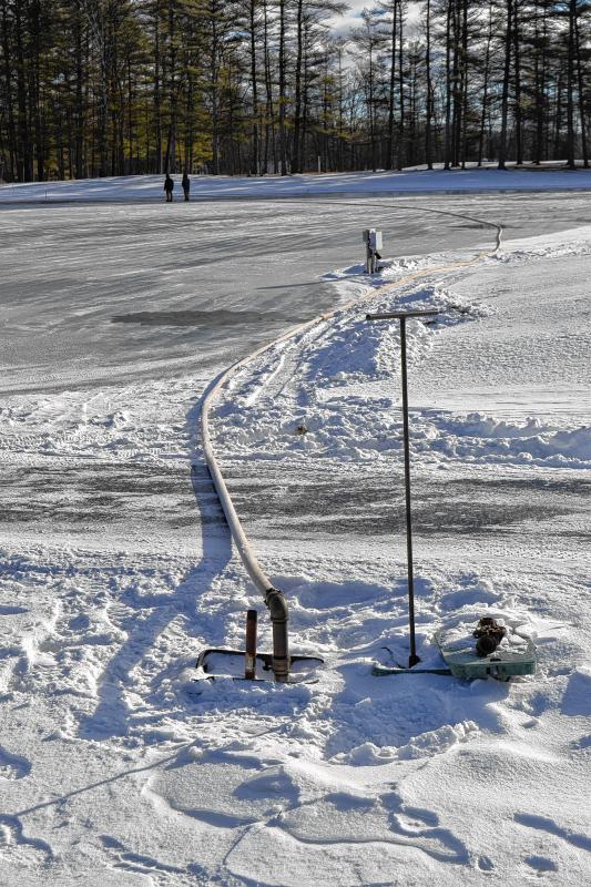 The pond spraying crew taps into a city water line at Beaver Meadow and uses seven, 50-foot hoses to water the ice. (TIM GOODWIN / Insider staff) -
