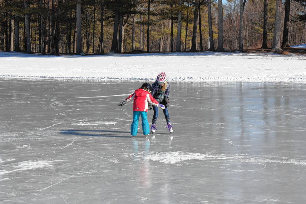 Nia Watts (left) holds her arms out to keep her balance while Daphne Wible stays close by for physical and moral support. The girls took to the Beaver Meadow ice with their sisters for some skating. (JON BODELL / Insider staff) -