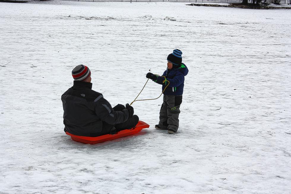 Finn Proulx, 2½, pulls his dad, Ryan Proulx, on a sled at White Park. They didn’t go very far. (JON BODELL / Insider staff) -
