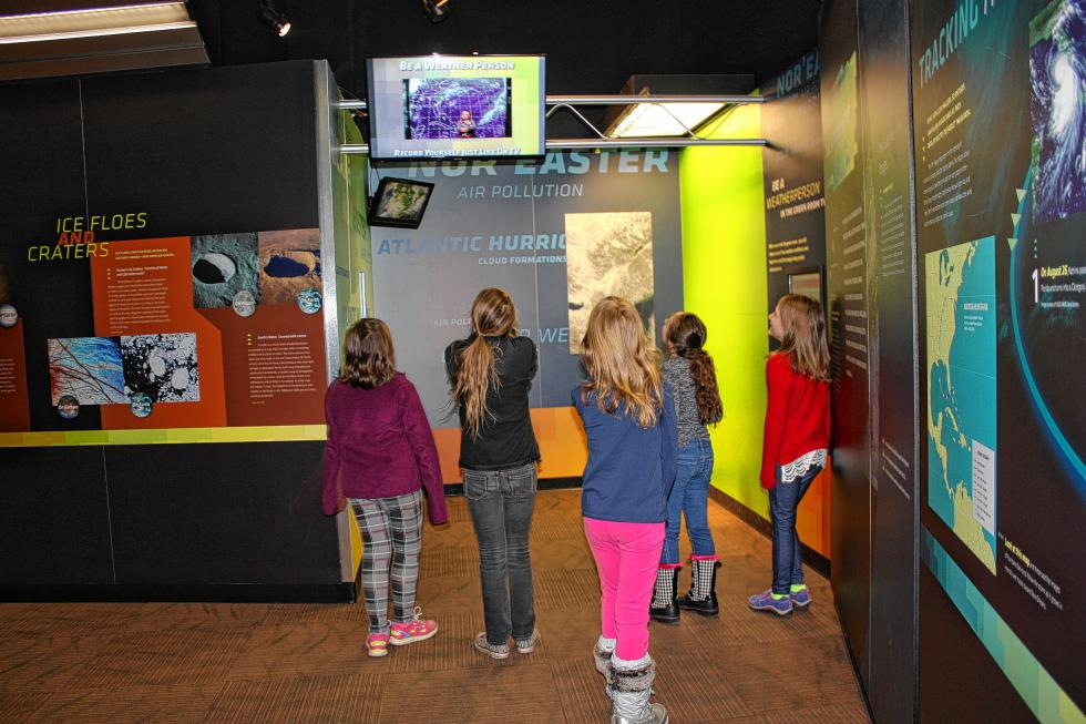 Girls from Chichester Central School watch a weather broadcast one of them just recorded. That's right, you can do the weather just like a real meteorologist – green screen, teleprompter and all – at the McAuliffe-Shepard Discovery Center. (JON BODELL / Insider staff) -