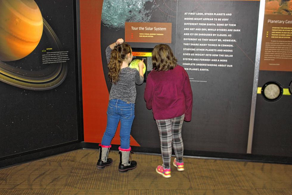 Savannah Eaton (right) and a friend take a look at a Tour of the Solar System exhibit at the McAuliffe-Shepard Discovery Center last week. The girls were there on a field trip from Chichester Central School. (JON BODELL / Insider staff) -