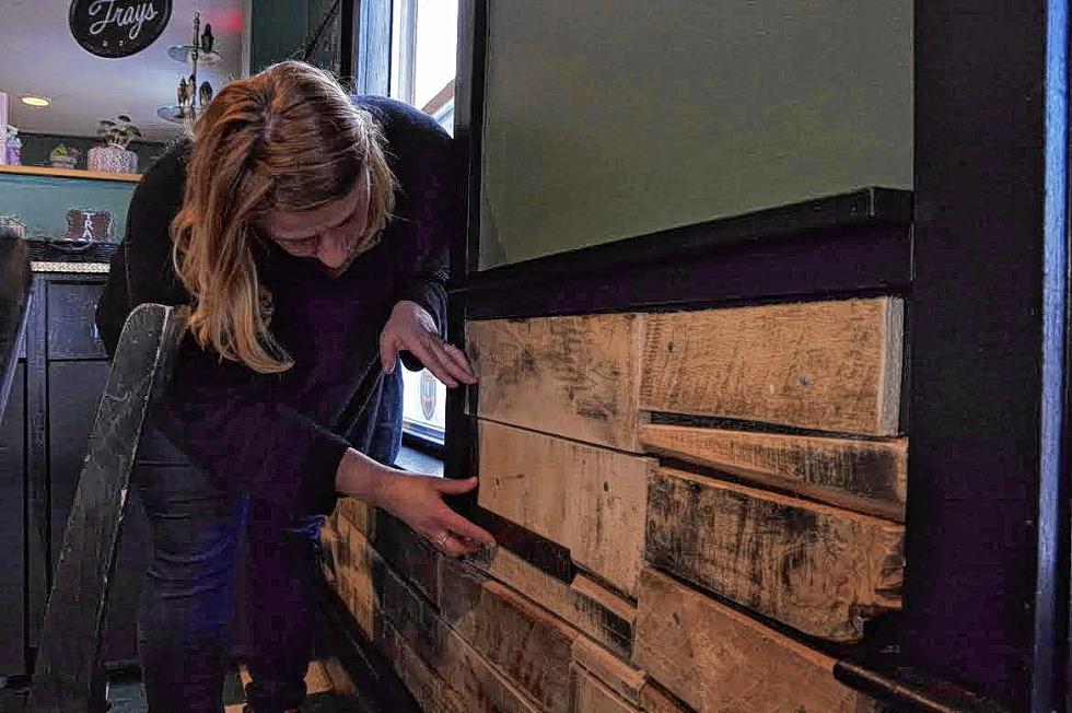 Lord-Smith applies some re purposed wood to the bottom portion of the wall at In A Pinch Cafe & Bakery. (Courtesy photo) -