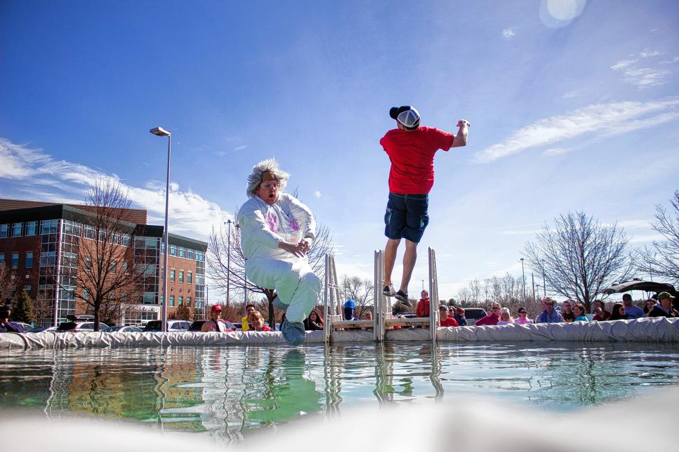 Jamie Tibbets, left, and his brother Derek, right, jump into the pool at the Courtyard Marriott Grappone Center for a Womenade Polar Plunge fundraiser in Concord Sunday.   (ELODIE REED/ Monitor staff) - ELODIE REED | Concord Monitor