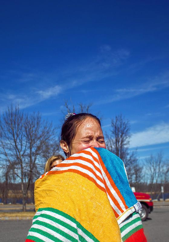 Sarah Burdette of Concord wipes off cold water after taking a dip during Womenade's 2nd Annual Polar Plunge Sunday.   (ELODIE REED/ Monitor staff) - ELODIE REED | Concord Monitor