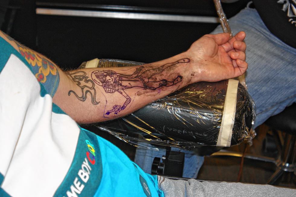 The outline of the lower half of the body is done. Don't worry – that smudged ink you see isn't permanent. The smudged ink is extra stuff that didn't enter the skin. It will be wiped away over and over again throughout the process of the tattoo. (JON BODELL / Insider staff) -