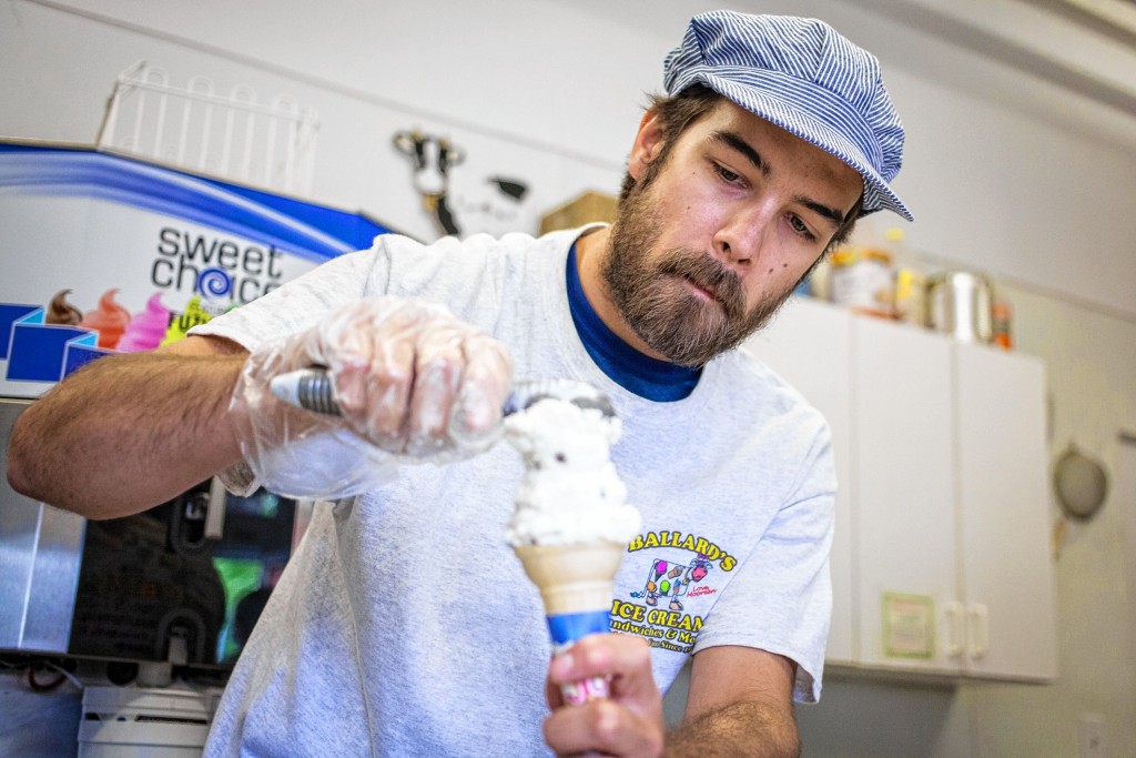 Elizabeth Frantz—Concord MonitorOwner Norm Ballard demonstrates how to score the first scoop of ice cream when making a cone at Ballard's Ice Cream in Concord on Wednesday
