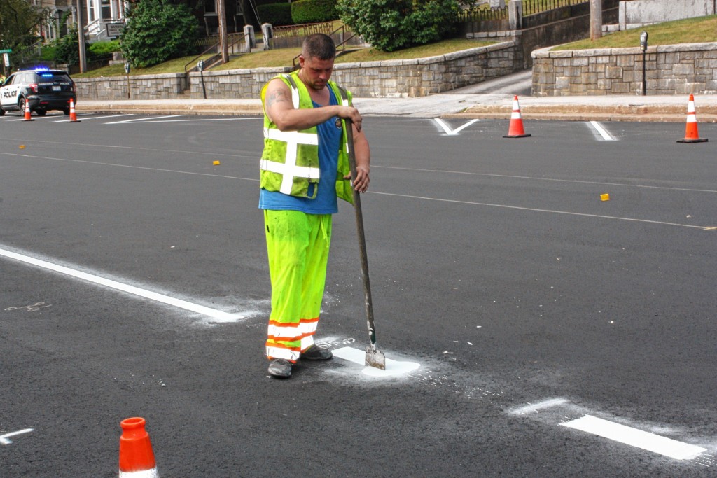 JON BODELL / Insider staffAl Danforth uses a scraper-type thing to scrape some excess paint off the road on South Main Street last week. Can’t have those lines bulging in the middle.