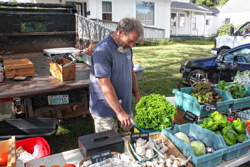 JON BODELL / Insider staff—Keith Descoteaux, owner of Still Seeking Farm in Gilmanton, weighs out some lettuce for a customer on the last day of the Penacook Farmers Market. The market wrapped up for the season last week, but will be back next year when things start warming up again.