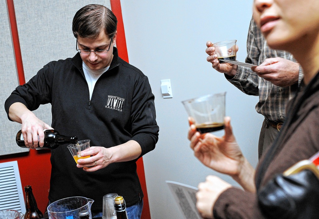 At opening night of the 2010 Snob Film Festival at Red River Theatres, Brian Parda (then with White Birch Brewery, now owner of Great North Aleworks) pours a beer while Nam Holtz and Ken Munney hold onto their samples.