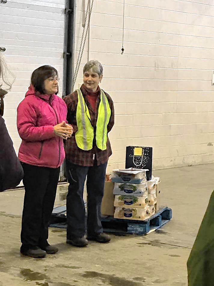 Maria Manus Painchaud (center right) accepts a nice donation for the Capital Region Food Program from Enterprise during the start of the holiday food basket project.