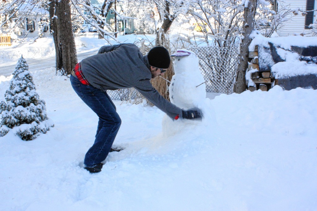 Jon does a little repair work to the snowman.