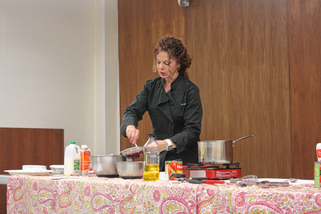Master chef Liz Barbour strains the seeds out of some raspberry puree during the Passionate Dishes for Your Valentine program at Concord Public Library last week.