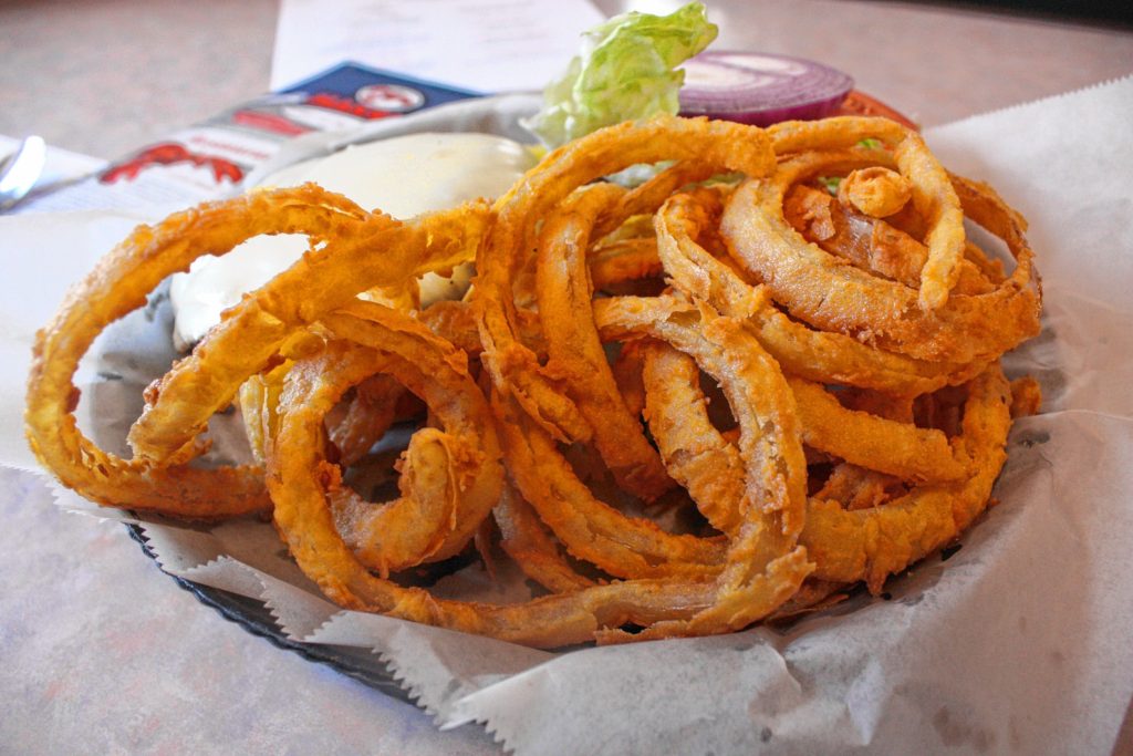 Makris Lobster & Steak House has regular French fries and sweet potato fries, but they're known for their famous, family-recipe onion rings. If your last name isn't Makris, you don't get the recipe, we were told. (JON BODELL / Insider staff)