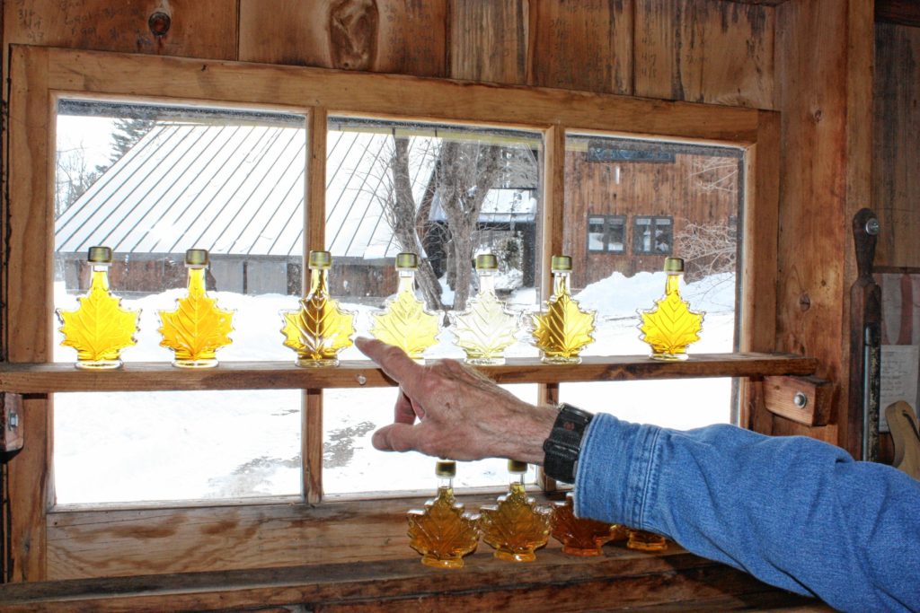 A seasoned maple syrup pro can tell a lot about the temperatures of a given season by looking at the color of the syrup. Darker syrup correlates to warmer temperatures, and lighter creations to colder temps. In this shot taken at Mapletree Farm in Concord, the first two bottles on the left are from this year – one for each boil owner Dean Wilber has done so far. After those two, the rest are bottles from last year’s season, in order. By looking at this photo, we can tell that last year started off a little warm (the first bottle is on the darker side), then it cooled off for a little while, which is why you see the very light colors in the middle. Then, at the end of the season when it was the warmest, the syrup was the darkest.