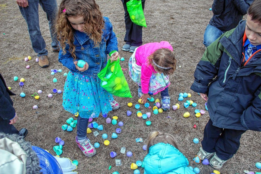 Brucea Camilo, 4, left, and her sister Ivana, 3, both of Manchester, pick up eggs at Mill Brook School in Concord Sunday.