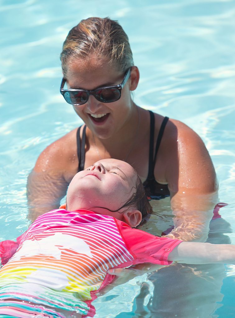 Lifeguard and swimming teacher Jillian Deland holds up Brooke Holt of Salisbury during their morning lesson at Merrill Park Monday morning.