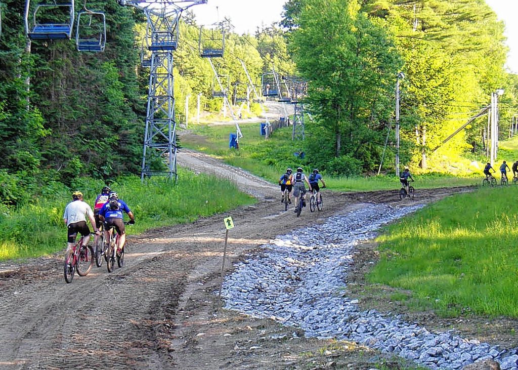 Competitors launch on the 24/12/6 hours of Pats Peak bike ride. The combination of mud and sunshine makes it more fun. This year’s Pats Peak Mountain Bikle Festival is June 14 and 15. (Tim Jones/EasternSlopes.com photo) Competitors take off for the 24/12/6 Hours of Pats Peak bike ride at the mountain in Henniker. Riders can compete solo or in teams of two, four or five. The event is June 14-15.  