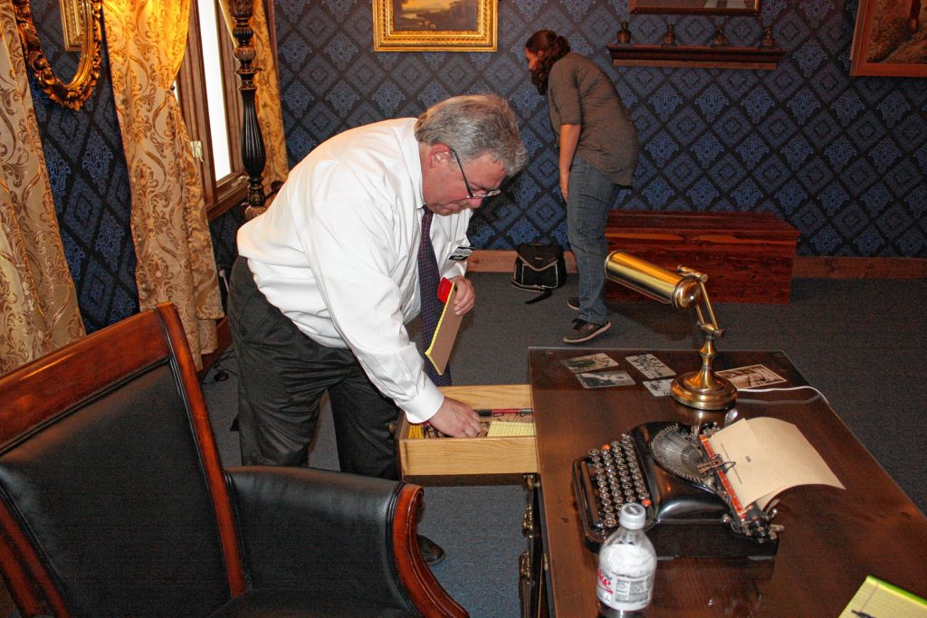 Advertising Director Tim Brady looks for clues in a desk at Escape Room Concord last week.  JON BODELL / Insider staff