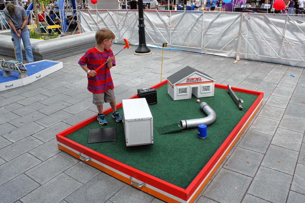 Owen Lanman, 5, watches his putt on the mini golf course during Market Days last week. He made a hole-in-one on this Sanel Auto PArts hole, which had special significance because his mom is a member of the Sanel family. JON BODELL / Insider staff