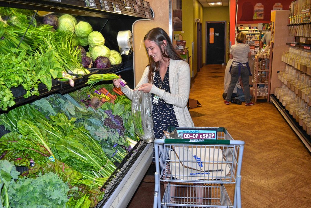 Ciara Navarria picks out some produce to fill an order under the Concord Food Co-op's new eShop. TIM GOODWIN / Insider staff