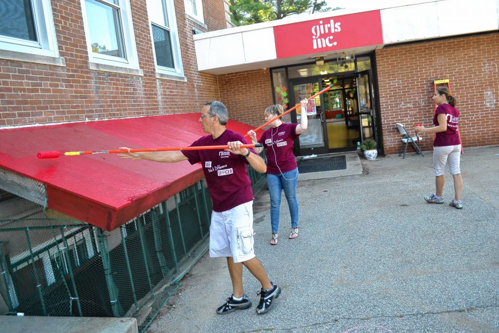 Above: Jim Bergeron and Susan Sullivan, both Lincoln Financial employees, roll out the red paint for the  awning at Girls Inc. at the former Eastman School during the Granite United Way’s annual Day of Caring. Below: It’s been a number of years since Tim washed a window, especially under the watchful eye of a supervisor, this time being Karen Billings of Girls Inc. (Photo by Mary Jane Ricker.)     